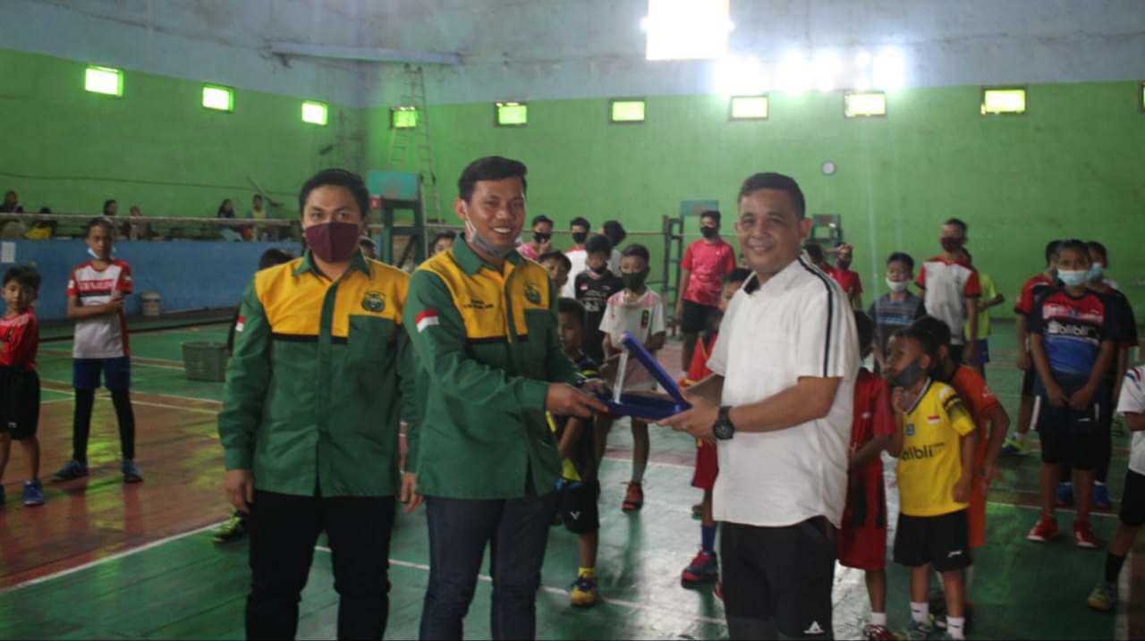 Budi Setiawan saat memberikan plakat penghargaan yang diterima oleh Ketum PBSI Kota Jambi