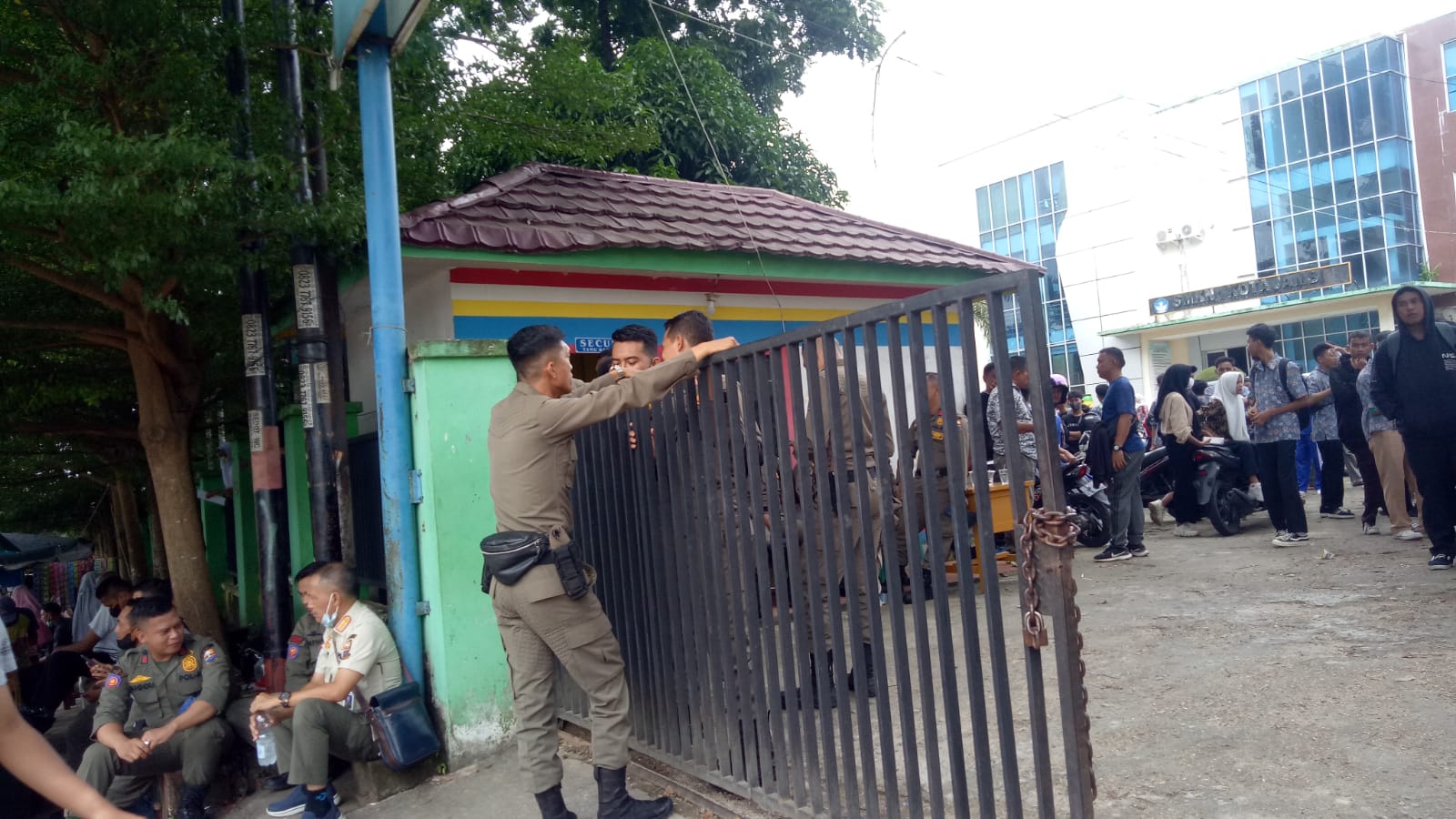 Petugas saat berjaga di depan SMKN 1 Kota Jambi usai bentrokan dengan siswa MA Labor