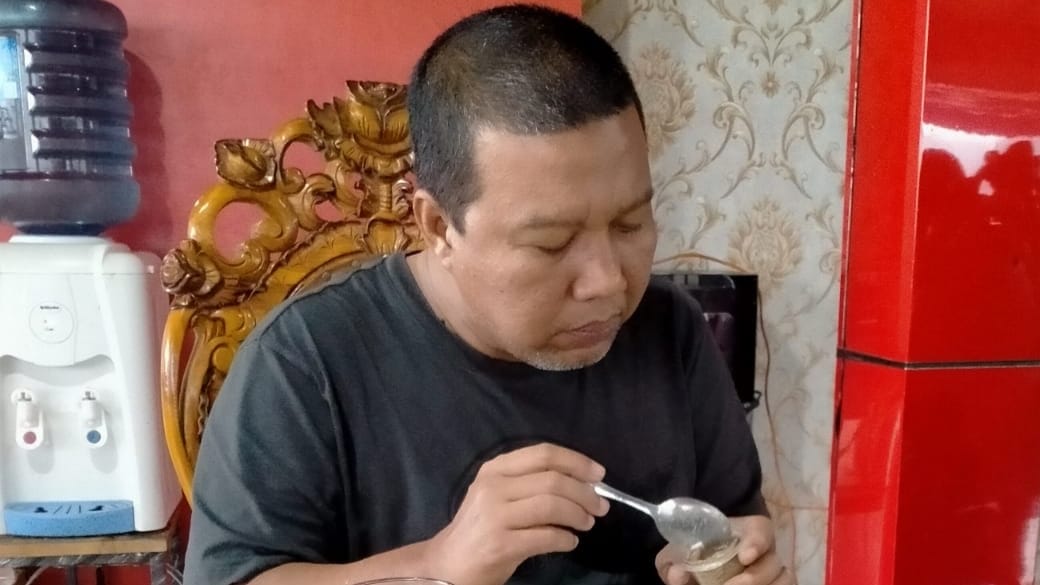 Romi saat menyantap ketan dan srikaya telur makanan khas Home Stay Bunga Sonsang