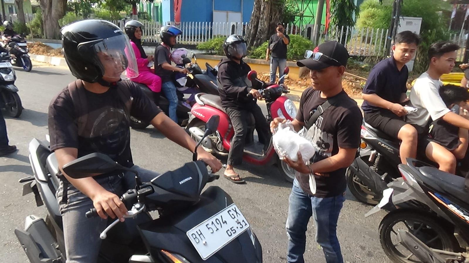 Adrianus saat bagikan masker ke pengendara