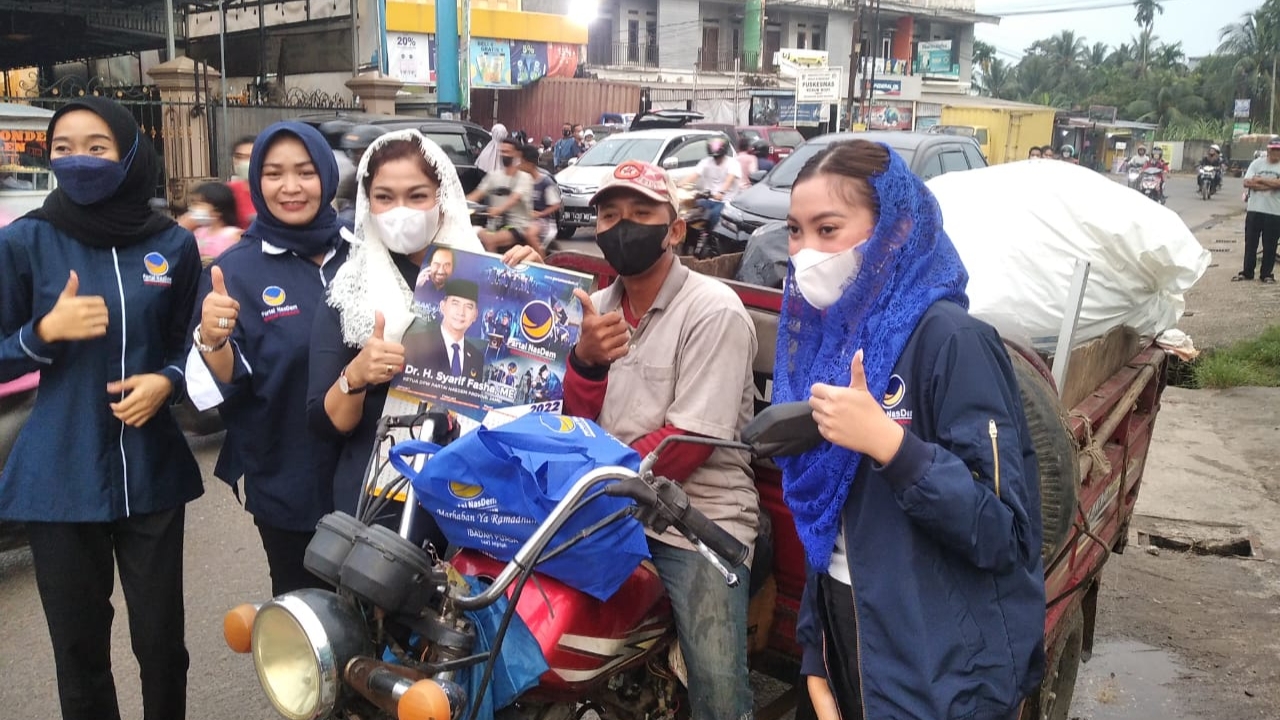 Tina Sofa dan kader Nasdem Jambi saat bagikan sembako jelang Ramadan 