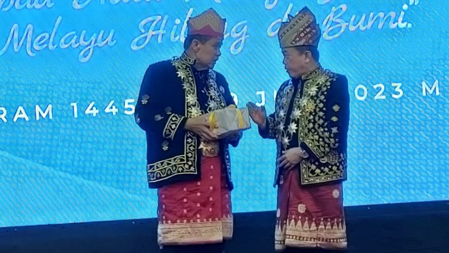 Hasan Basri Agus menyerahkan buku daras adat Melayu Jambi kepada Al Haris, Rabu (19/7)