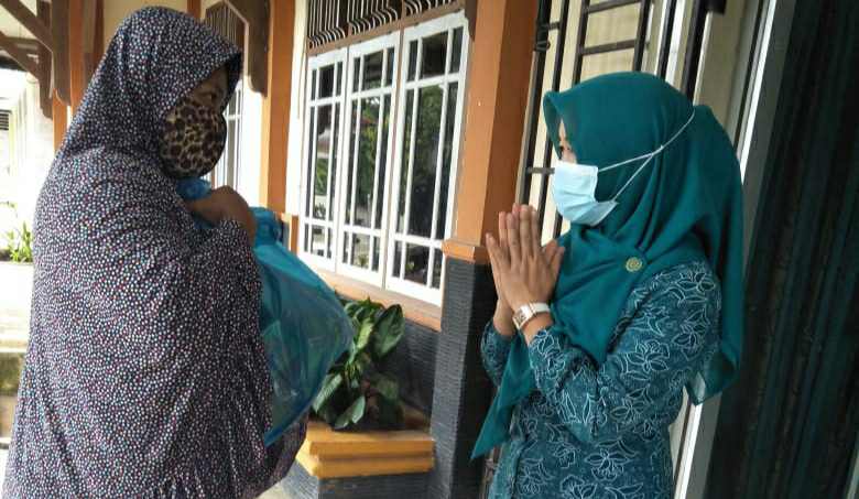 Ketua PKK Merangin Hesnidar Haris saat berikan bantuan